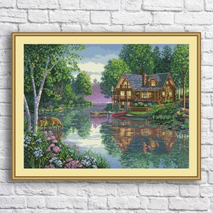 Puede incluir: Una pintura de una cabaña de madera en un lago con el reflejo de la cabaña en el agua. Hay árboles y arbustos alrededor del lago y dos ciervos en primer plano.