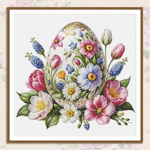 Könnte beinhalten: Ein weißes Porzellan-Ei, verziert mit goldenen Akzenten und bunten Blumen. Das Ei ist von einem Strauß aus rosa, weißen und blauen Blumen umgeben.