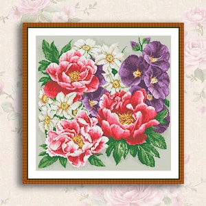 May include: A framed cross-stitch embroidery featuring a bouquet of pink, white, and purple flowers. The flowers are arranged in a cluster with green leaves and a light gray background.