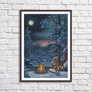 Puede incluir: Una escena de invierno nevada con una fogata ardiendo en primer plano. El fuego está rodeado de nieve y árboles. Hay dos raquetas de nieve apoyadas contra un tronco de árbol. Una luna llena brilla intensamente en el cielo nocturno.