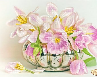 May include: A bouquet of pink tulips with yellow centres in a silver vase. The tulips are arranged in a cluster, with some of the stems spilling out of the vase. The vase is decorated with a pattern of small dots.