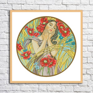 May include: A cross-stitch pattern featuring a woman with long dark hair surrounded by red poppies and wheat stalks. The woman is wearing a gray dress and has her hands on her face. The pattern is set against a blue and yellow background.