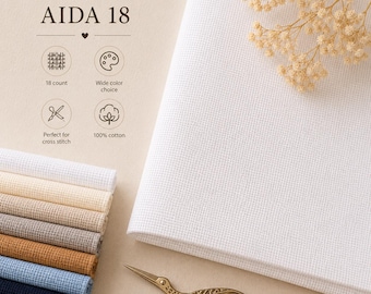 Puede incluir: Tela Aida 18 blanca para punto de cruz, con una pila de muestras de tela de colores. La imagen incluye el texto "AIDA 18", "18 count", "Amplia gama de colores" y "100% algodón". También se ven unas tijeras doradas y un bastidor de bordado.