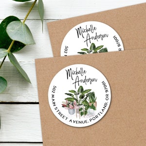 May include: Round white sticker with a black and white design featuring a potted plant illustration and the text "Michelle Anderson 502 Main Street Avenue, Portland, OR 97001".