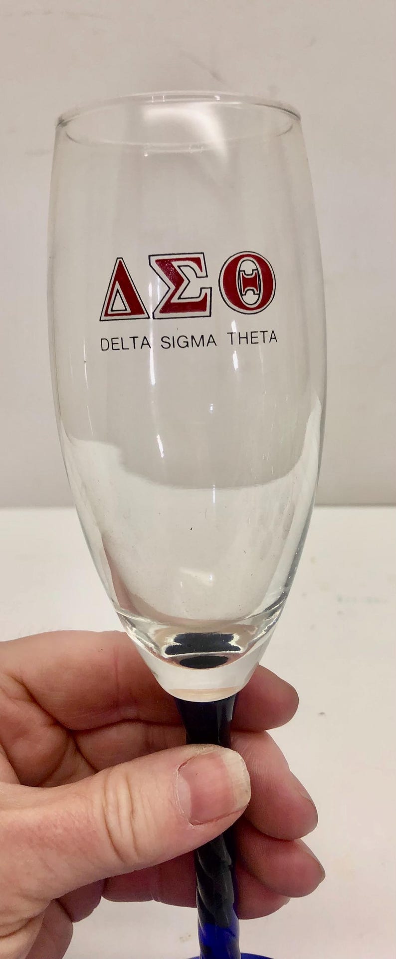 Puede incluir: Una taza de cer&aacute;mica blanca con un asa negra y el texto "But First, Coffee" en negro y negrita. La taza est&aacute; sobre una superficie blanca. La taza mide aproximadamente 10 cm de alto.