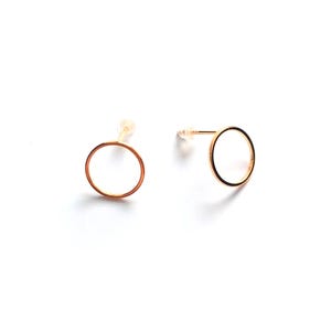 Peut inclure: Deux boucles d'oreilles à clous en forme de cercle ouvert de couleur or sur fond blanc. Les boucles d'oreilles ont un design simple et minimaliste, avec une tige et un fermoir. Les boucles d'oreilles sont petites et délicates.
