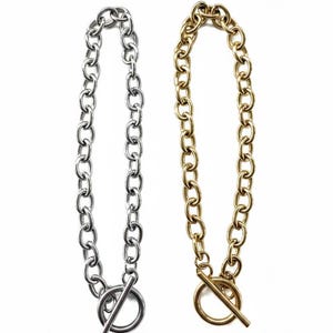 Può includere: Due collane con un design a catena. Una è color argento, l'altra dorata. Ognuna ha una chiusura circolare con chiusura a barra. Le collane sono esposte su sfondo bianco.
