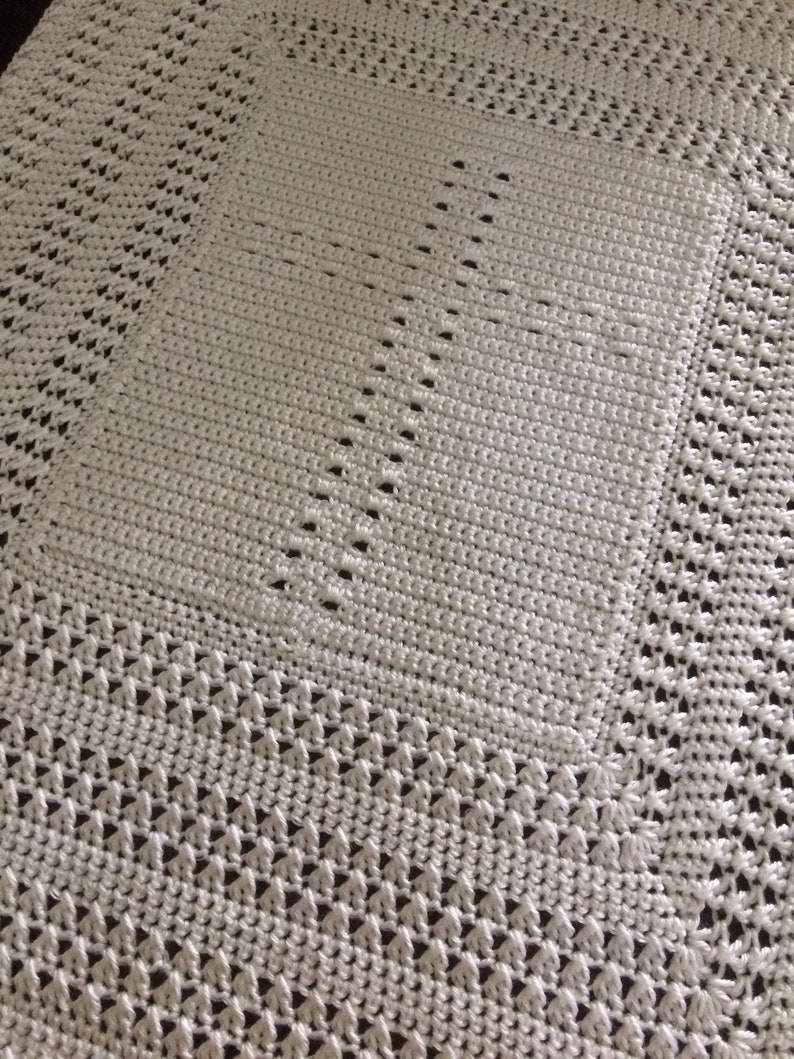 May include: White crocheted blanket with a diamond pattern.