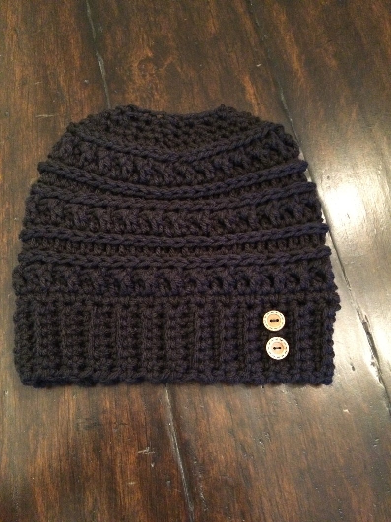 May include: A black crocheted beanie with two brown buttons.