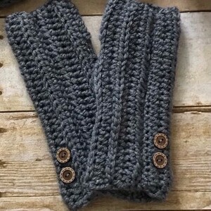 May include: Gray crocheted fingerless gloves with brown button accents.