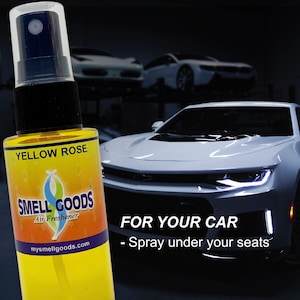 May include: A yellow bottle of car air freshener with a black spray nozzle and the text "YELLOW ROSE" and "SMELL GOODS Air Freshener" on the label. The bottle is in front of a white car with the text "FOR YOUR CAR - Spray under your seats".