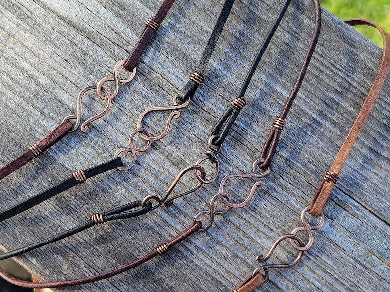 May include: Five leather cord necklaces with copper wire accents and copper wire clasps. The cords are brown, black, and brown.
