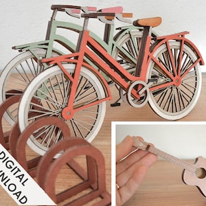 Op de afbeelding: Houten fietsmodellen in groen, koraal en natuurlijk hout, met witte banden. De afbeelding bevat ook een houten gitaarmodel en een fietsenrek. De woorden "DIGITALE DOWNLOAD" zijn zichtbaar.