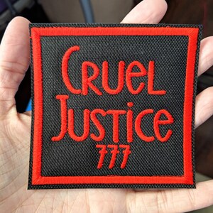 Może przedstawiać: Czarna naszywka haftowana z czerwonymi szwami. Naszywka zawiera napis "Cruel Justice 777".