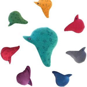 May include: Seven colorful knitted hats with a variety of patterns, including foxes, mushrooms, and squirrels. The hats are all in different colors, including green, blue, red, orange, purple, and gray.