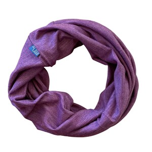 Könnte beinhalten: Lilafarbener Infinity-Schal aus weichem, dehnbarem Stoff. Der Schal hat ein kleines blaues Etikett mit dem Text "GUCIP KIND" darauf.