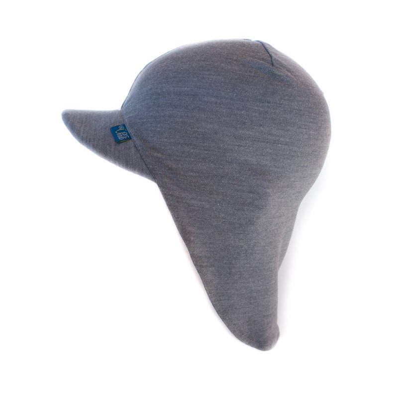 May include: Gray wool hat with a long flap in the back and a short brim in the front. The hat has a small blue label with the word "SUPER" on it.