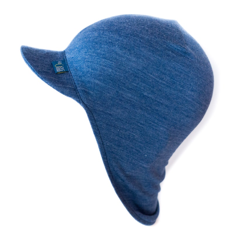 May include: A blue denim sun hat with a wide brim and a small logo on the side. The hat has a long flap that can be pulled down to cover the neck and ears.