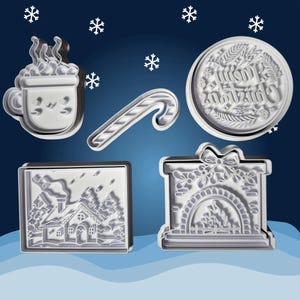 Può includere: Set di cinque tagliabiscotti di Natale in plastica bianca. I tagliabiscotti hanno la forma di una tazza di cioccolata calda, una canna di zucchero, una casa, un camino e un cerchio con le parole "Buon Natale" all'interno.