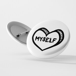May include: White button with a black and white hand-drawn heart that says "MYSELF" on it.