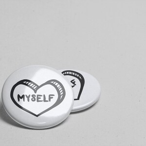 May include: Two white round buttons with black outlines. The button on the left has a black heart with the word "MYSELF" inside. The button on the right has a black design that resembles a stylized letter "S".