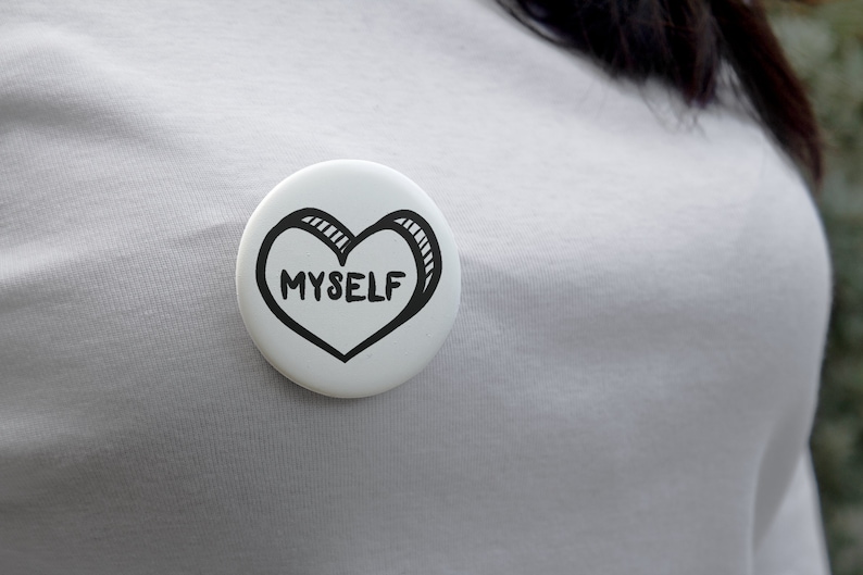 May include: White button with a black hand-drawn heart that says "MYSELF" inside.