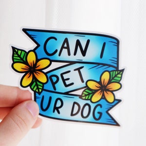 May include: Blue and white sticker with the text "Can I Pet Ur Dog" in a banner style with yellow flowers on either side.