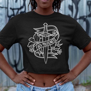 Op de afbeelding: Zwart getailleerd T-shirt met een witte afbeelding van een zwaard met bloemen en een banner met de tekst "F*CK POLITENESS".