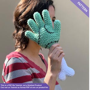 May include: A crocheted hand in mint green with black stitching and a white bone-shaped wrist. The image includes the text "PATTERN" and "This is a PDF file Tutorial, not a finished Product. Ceci est un Tutoriel au format PDF et non un produit fini."