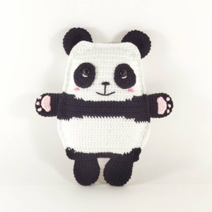 May include: A handmade crochet panda bear pillow in white and black. The panda has black button eyes, pink cheeks, and a smiling mouth. The panda's arms and feet have pink paw pads.