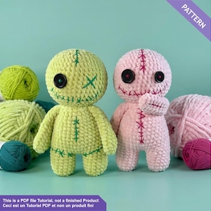 Könnte beinhalten: Zwei handgefertigte Häkelpuppen, eine hellgrüne und eine rosa, mit aufgestickten Details und Knopfaugen. Die Puppen werden mit Wollknäueln in Grün-, Rosa- und Türkistönen präsentiert. Der Text "PATTERN" ist enthalten.