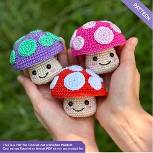 Puede incluir: Tres figuras de setas de ganchillo en tonos morado, rosa y rojo, cada una con lunares blancos y caras sonrientes. Las setas están sostenidas en las manos de una persona. La imagen incluye el texto "PATTERN" y "This is a PDF file Tutorial, not a finished Product".