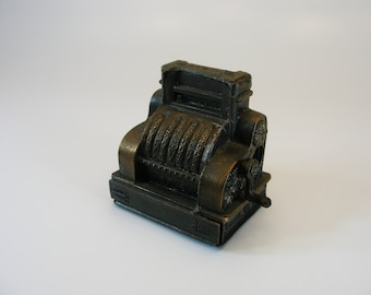 Sacapuntas con forma de máquina sumadora de metal fundido a presión, estilo antiguo.
