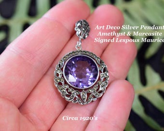 Può includere: Ciondolo in argento Art Déco con un'ampia ametista rotonda e sfaccettata. Il ciondolo è circondato da pietre di marcasite e ha un'ansa decorativa. Il testo sull'immagine recita "Art Deco Silver Pendant Amethyst & Marcasite Signed Lespous Maurice Circa 1920's."