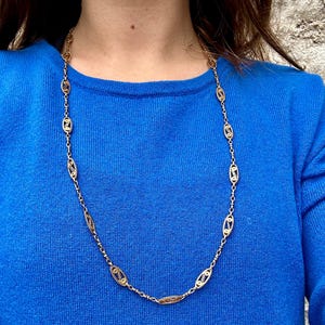 May include: A gold chain necklace with oval-shaped links. The chain is made of two different shades of gold, creating a unique and elegant look.