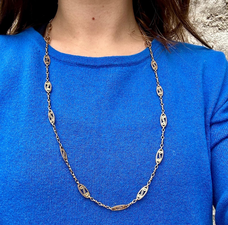 May include: A gold chain necklace with oval-shaped links. The chain is made of two different shades of gold, creating a unique and elegant look.