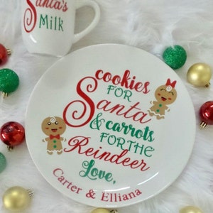 May include: White ceramic plate with red and green text that reads "Cookies for Santa & carrots for the Reindeer Love, Carter & Elliana". The plate features a gingerbread man and woman illustration.