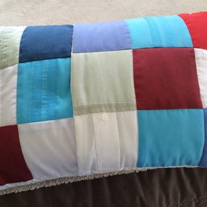 May include: A patchwork pillow made from different colored fabric scraps, including white, blue, red, and green. The pillow is made with a variety of textures and patterns.