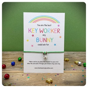 Könnte beinhalten: Ein grünes Armband aus Schnur mit einem silbernen Hasenanhänger und einer Karte mit der Aufschrift "You are the best KEY WORKER any BUNNY could ask for".
