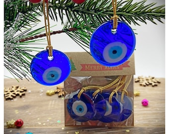 May include: A set of six blue glass evil eye ornaments with gold string for hanging on a Christmas tree. The ornaments are in a clear plastic bag with a brown paper tag that says "Merry Xmas".