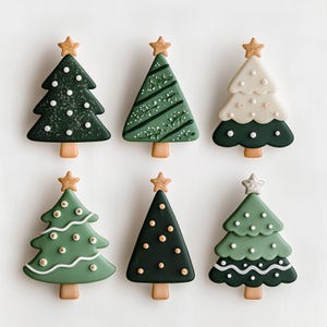 May include: Six Christmas tree-shaped cookies with various green and white icing designs. Each cookie has a gold star on top and a brown trunk. The cookies are arranged on a white surface.
