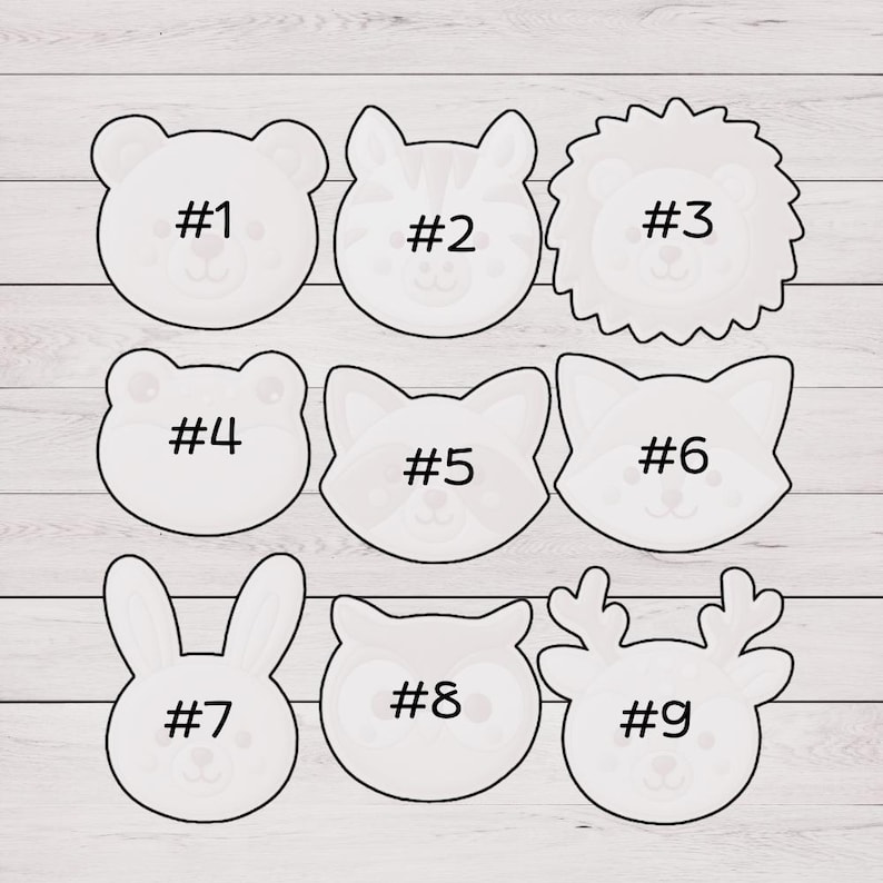 May include: Nine white animal-shaped cookie cutters. The shapes include a bear, tiger, lion, bear, fox, fox, bunny, owl, and reindeer. Each cutter is labeled with a number from #1 to #9.