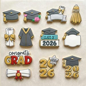 May include: Assortment of graduation-themed cookies. Designs include mortarboards, diplomas, graduation gowns, and cookies with the text "Congrats Grad" and "Class of 2026". The cookies are decorated with gold, gray, white, and red icing.