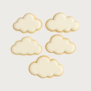Può includere: Cinque biscotti a forma di nuvola con glassa bianca e un bordo marrone chiaro. I biscotti sono disposti su uno sfondo bianco. Queste prelibatezze sono perfette per un baby shower o una festa a tema.