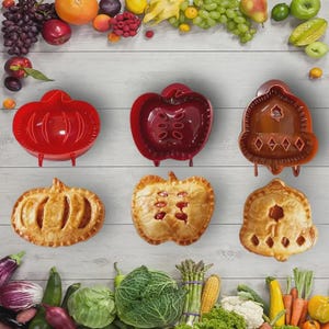 May include: A collection of pie makers in the shapes of a pumpkin, apple, and a decorative pie. The pie makers are red and brown. The image also shows freshly baked pies in the same shapes, with a variety of fruits and vegetables.