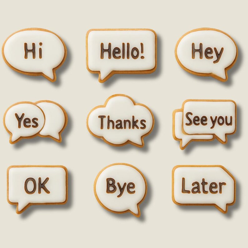 K&ouml;nnte beinhalten: Neun Kekse in Sprechblasenform mit wei&szlig;er Glasur und braunem Text. Die Kekse sagen "Hi", "Hello!", "Hey", "Yes", "Thanks", "See you", "OK", "Bye" und "Later". Die Kekse haben einen hellbraunen Rand.