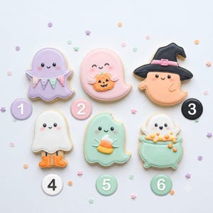 May include: Six decorated sugar cookies shaped like ghosts with various accessories. One ghost is purple with a banner reading BOO, one is pink holding a pumpkin, one is orange wearing a black witch hat, one is white wearing orange boots, one is mint green eating candy corn, and one is white in a mint green cauldron.