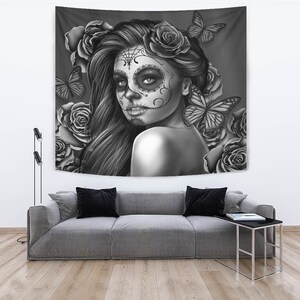 May include: Black and white tapestry featuring a woman with a sugar skull makeup design, surrounded by roses and butterflies.