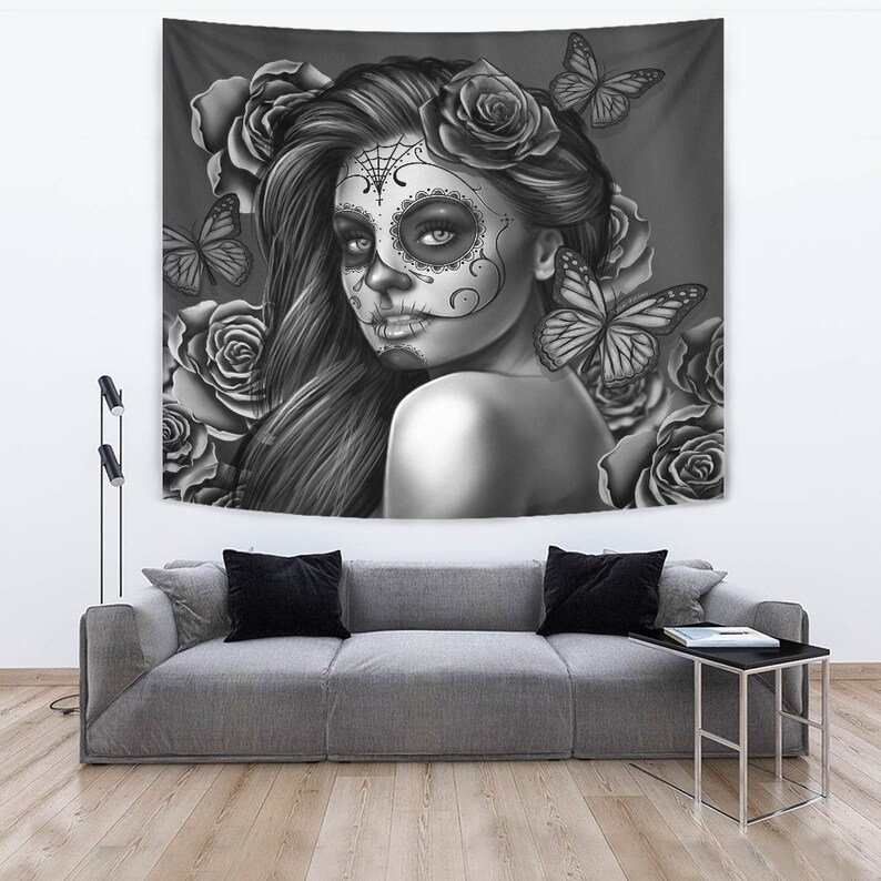 May include: Black and white tapestry featuring a woman with a sugar skull makeup design, surrounded by roses and butterflies.