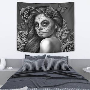 May include: Black and white tapestry featuring a woman with a sugar skull makeup design, surrounded by roses and butterflies.